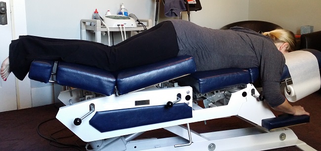 Chiropractic treatment table with person on it